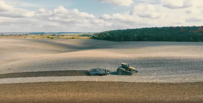 Це панорамний знімок сільськогосподарських робіт на відкритому полі.