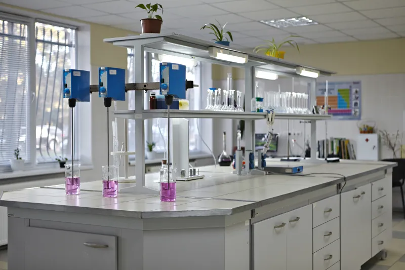 Це зображення світлого та сучасного лабораторного приміщення, обладнаного для хімічних або біологічних досліджень.